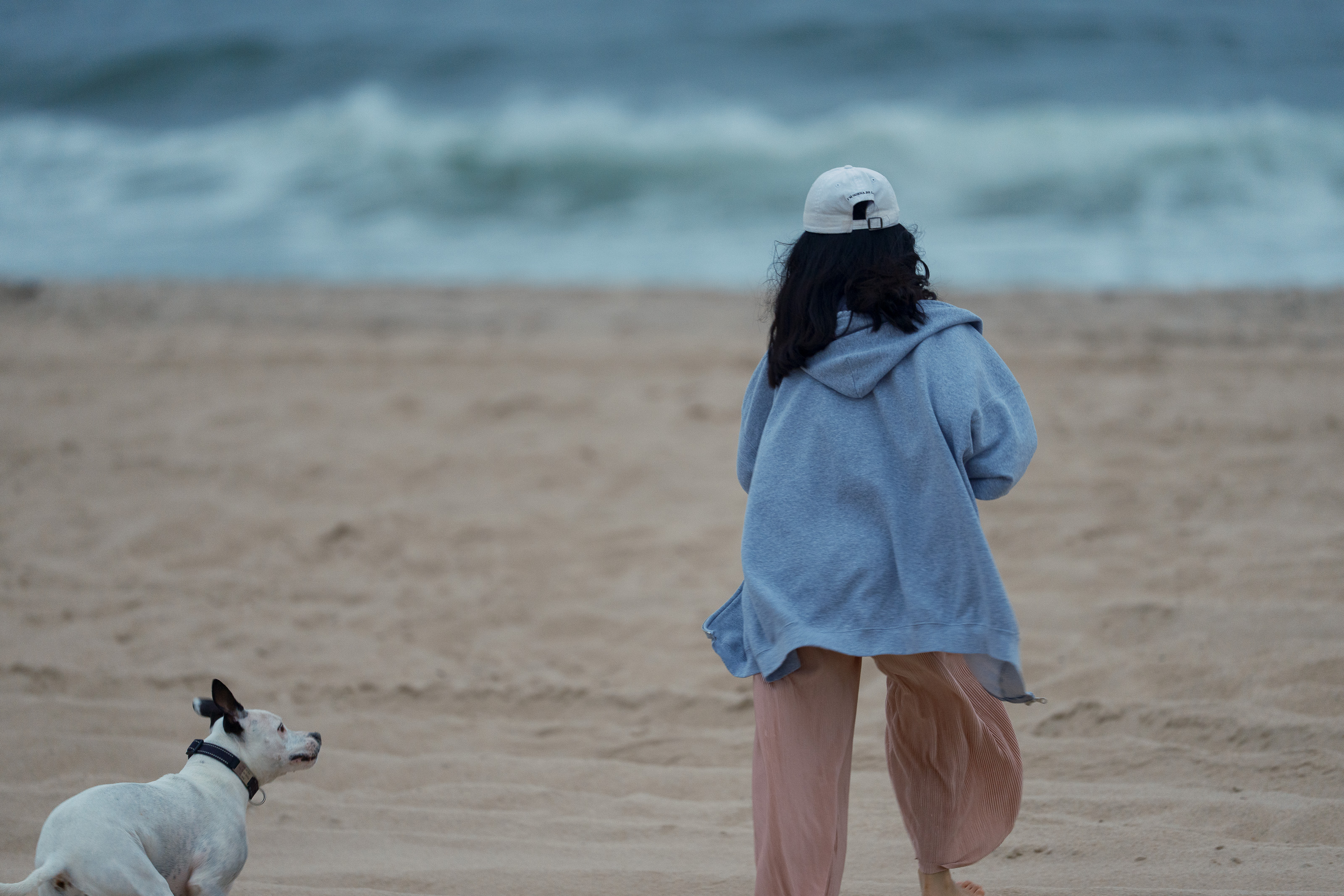 Kota looking up at friend with waves crashing in the background